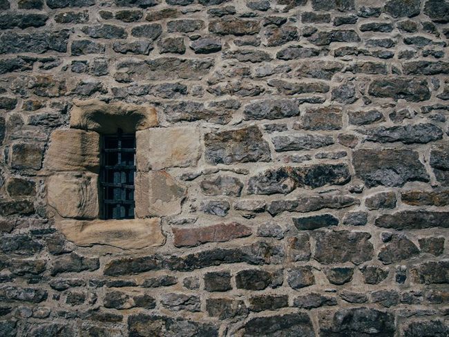 Un muro de piedra con una pequeña ventana.