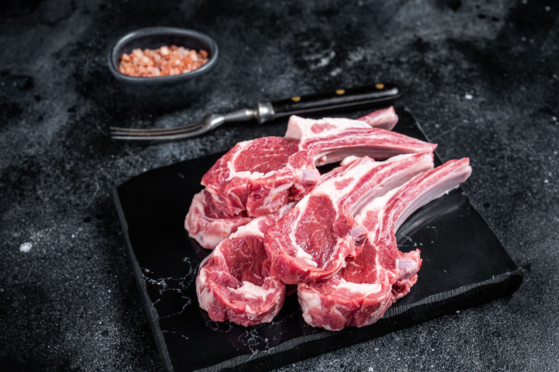 Plusieurs morceaux de bœuf sur une assiette à côté d'une fourchette