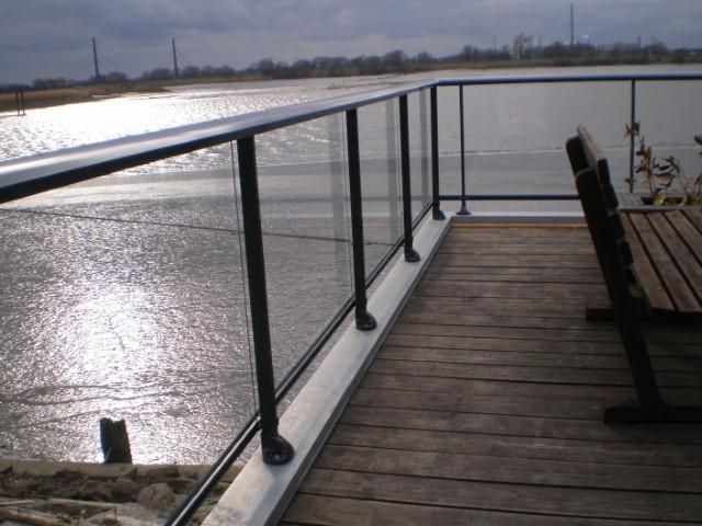 Terrasse en bois avec balustrade en verre.