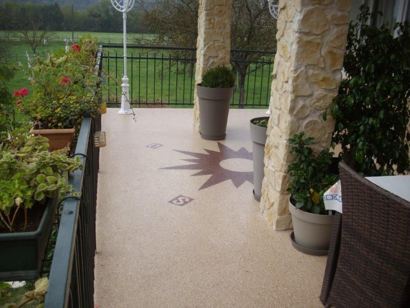 Terrasse en résine avec un motif décoratif rouge de rose des vents