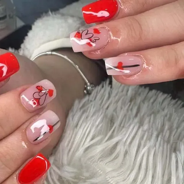 Un primer plano de las uñas de una mujer con corazones en ellas.