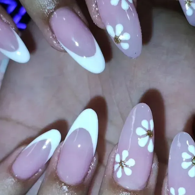 Un primer plano de las uñas de una persona con flores.