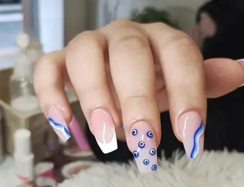 Un primer plano de las uñas de una persona con un diseño azul y blanco.