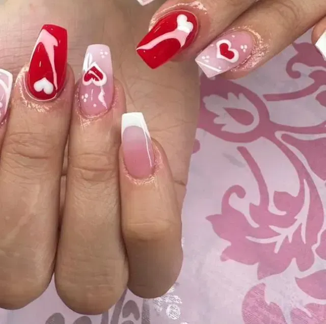 Un primer plano de las uñas de una mujer con corazones en ellas.
