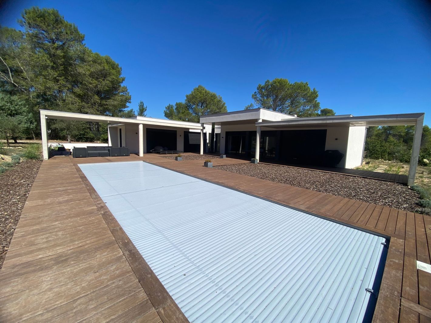 Terrasse en bois entourant une piscine creusée