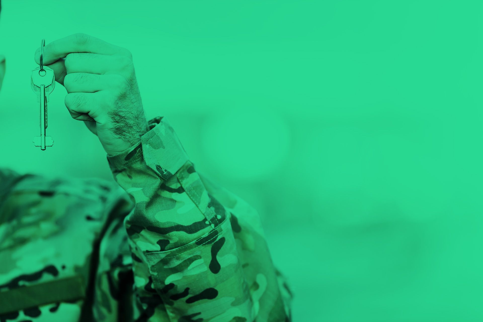 Le bras d'un homme en habit militaire tenant un trousseau de clefs