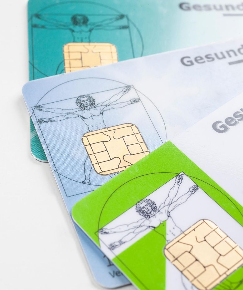 Stapel bunter SIM-Karten mit sichtbaren Goldchips auf weißem Grund