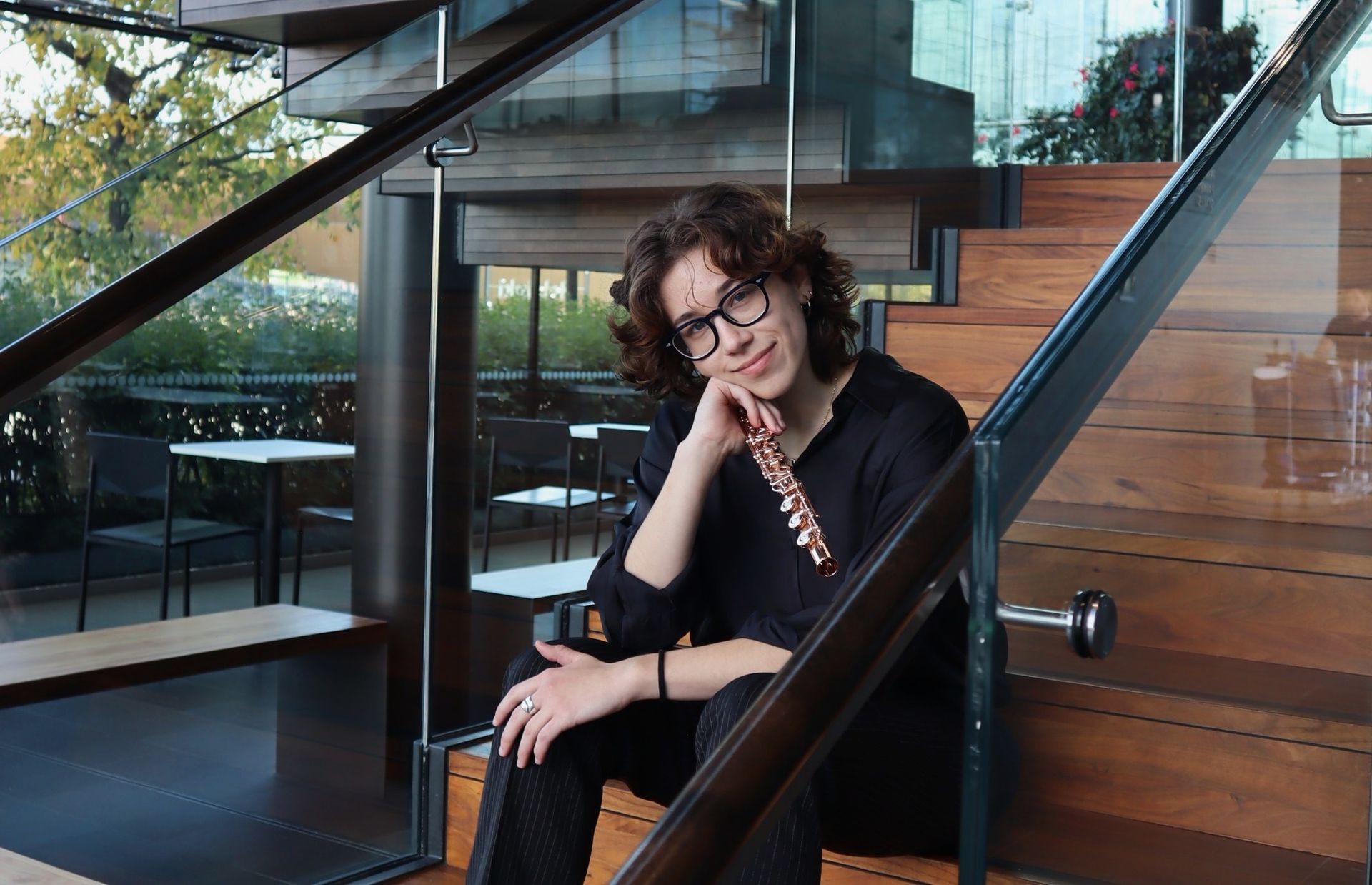 Nahaufnahme einer Violine, die in einem Orchester gespielt wird; im Hintergrund sind andere Musiker