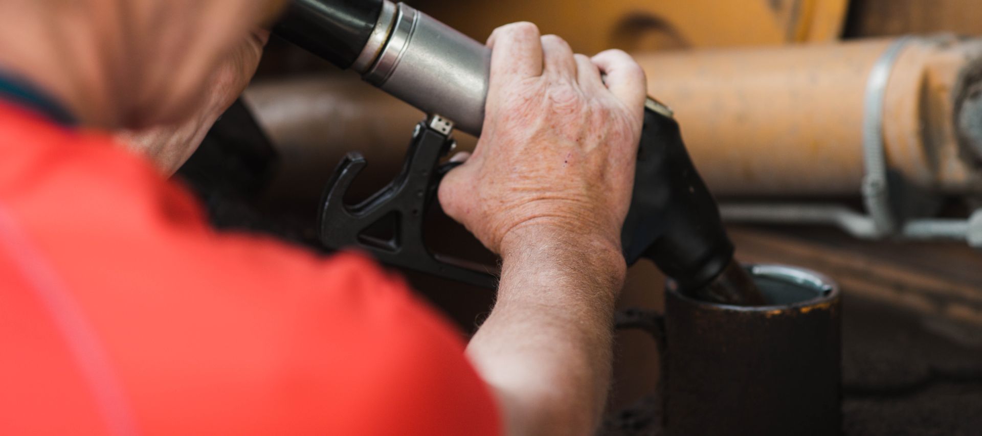Un homme ravitaille un tracteur à la station-service