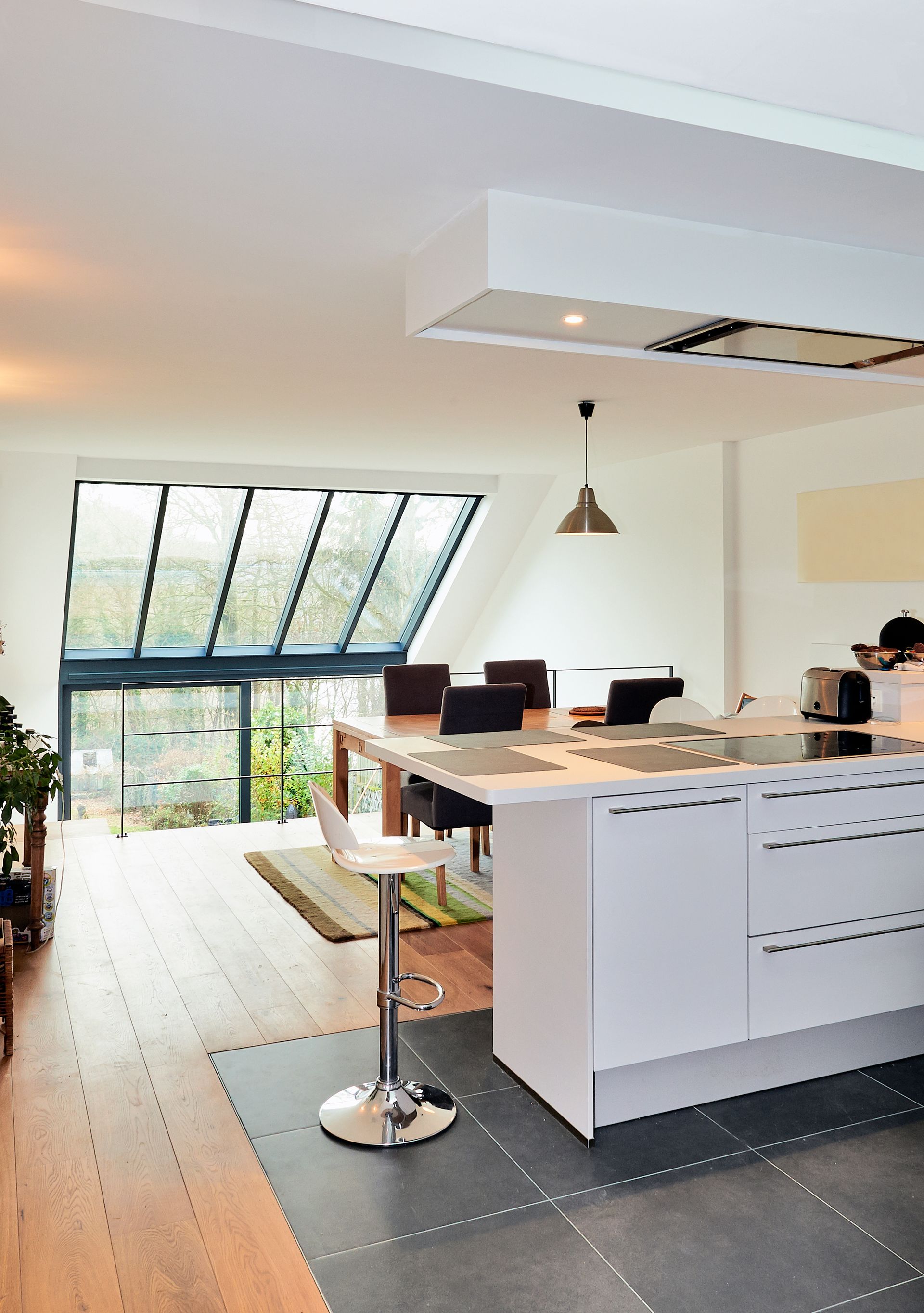 Cuisine moderne et lumineuse avec îlot central, tabouret de bar, espace de travail pour ordinateur portable