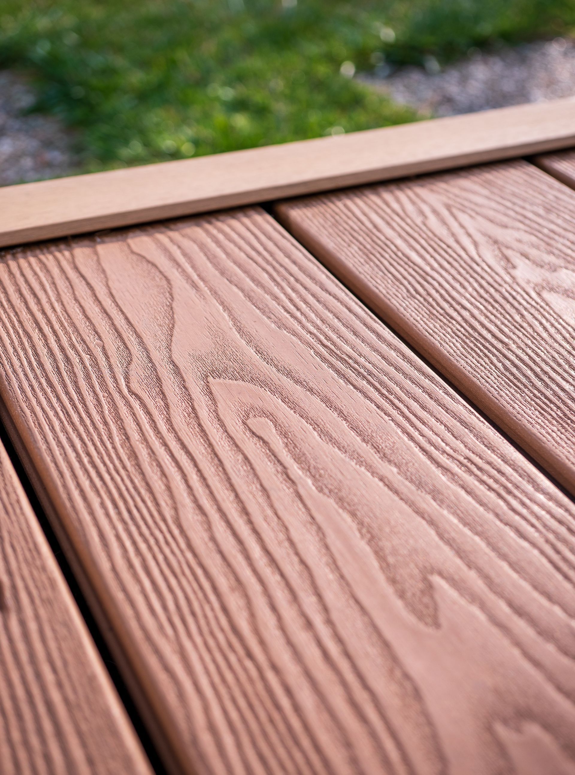 Gros plan sur des planches de terrasse en bois, laissant apparaître le grain du bois.