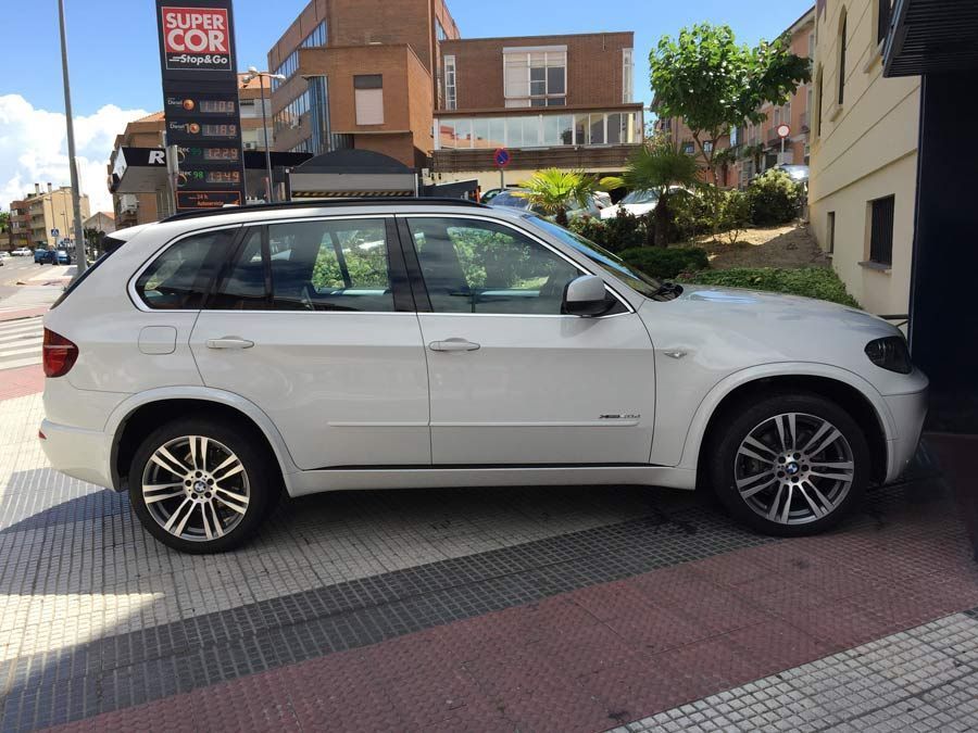 Una camioneta blanca está estacionada frente a una estación de servicio Super Cor.