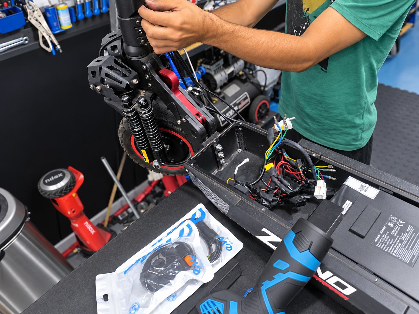 Técnico trabajando en la reparación de un patinete eléctrico en el taller Hack Ecomobility.