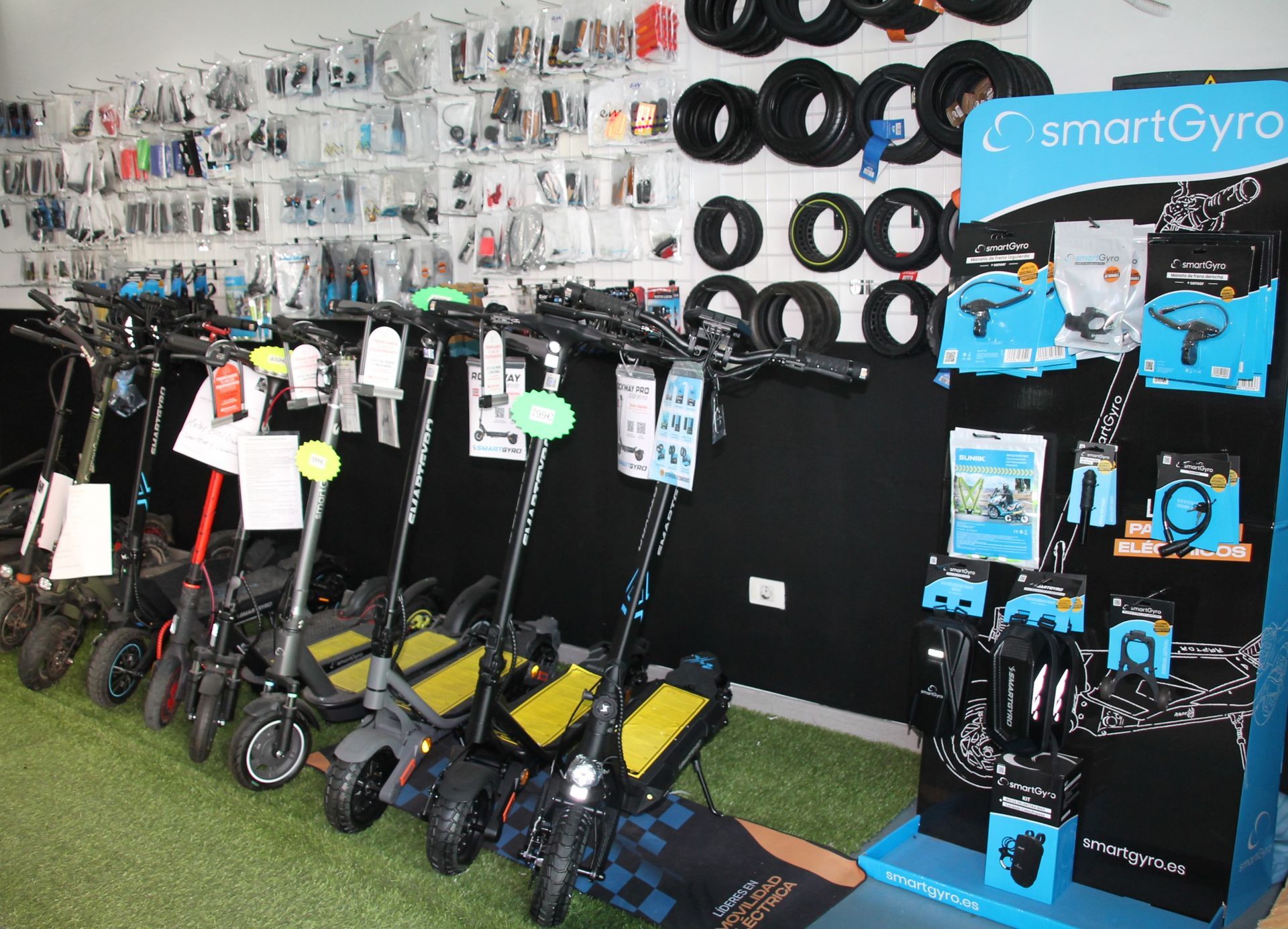 Una fila de patinetes eléctricos están alineados en una tienda.