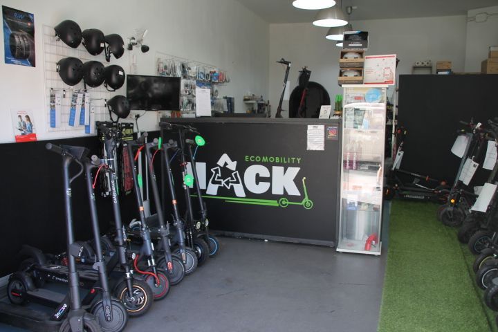 Una fila de scooters están alineados en una tienda llamada hack