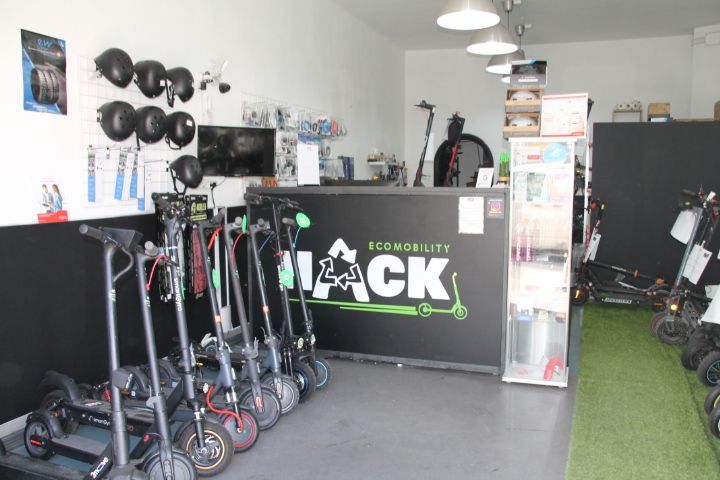 Una fila de scooters están alineados en una tienda llamada hack