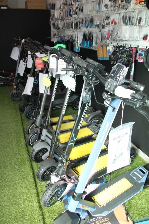 Una fila de patinetes eléctricos están alineados en una tienda.