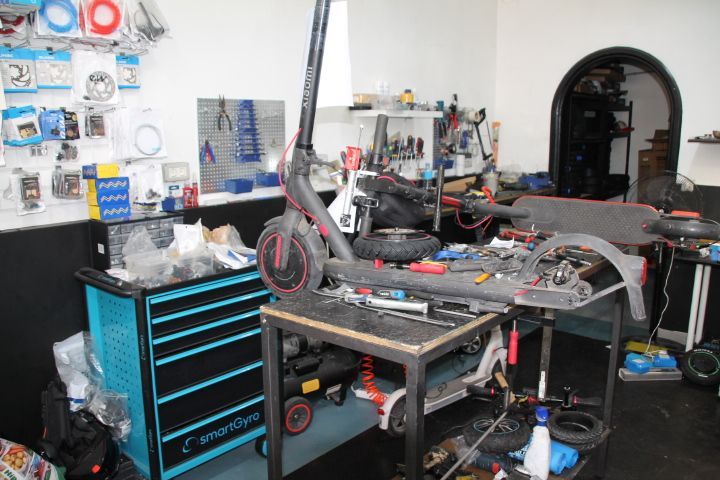 Un scooter está sentado encima de una mesa en un taller.