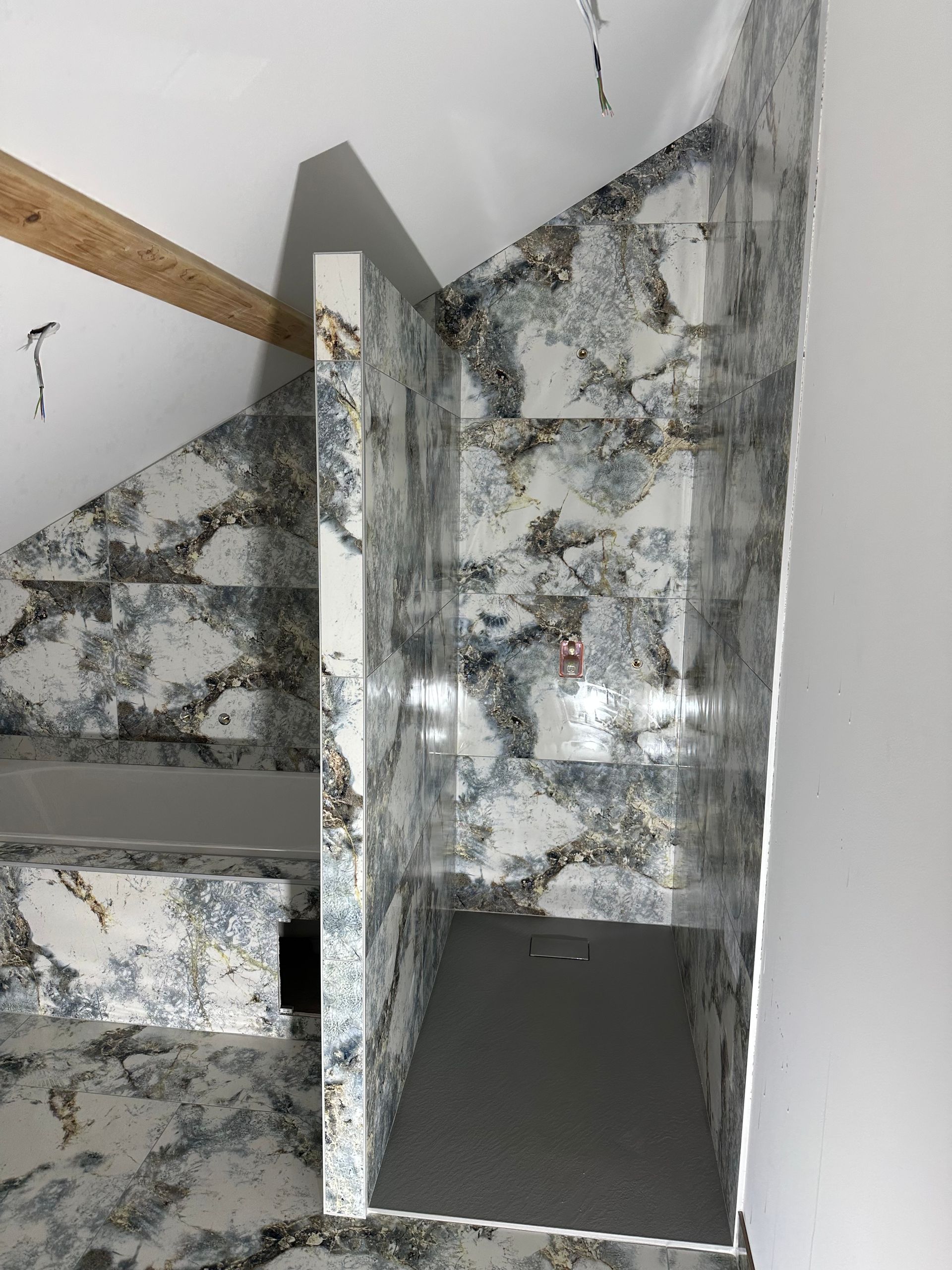 Pièce vide avec parquet clair, murs beiges et une porte ouverte donnant sur un couloir lumineux