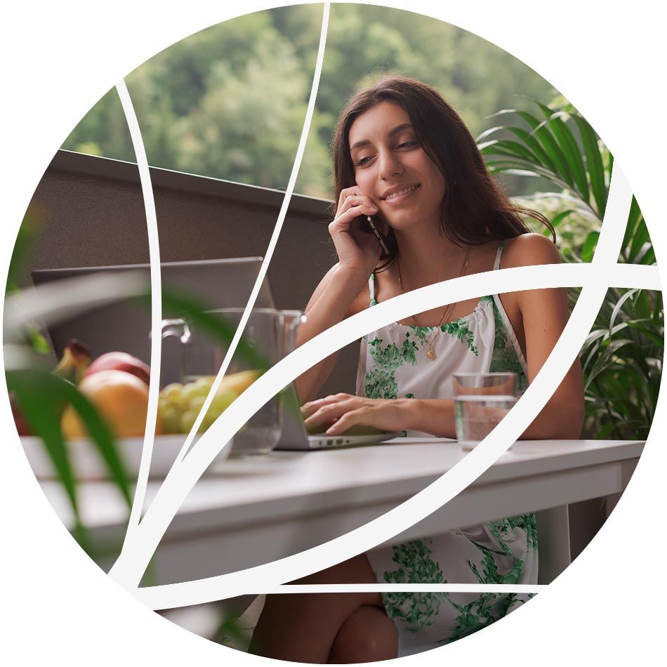 Femme au téléphone assise à une table de jardin 