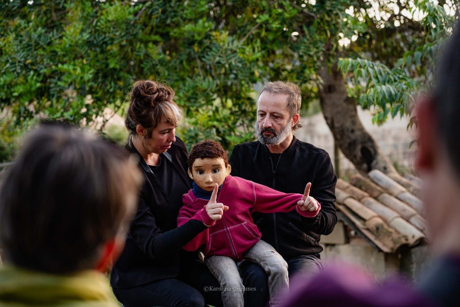 Un hombre y una mujer sostienen un niño en sus brazos.