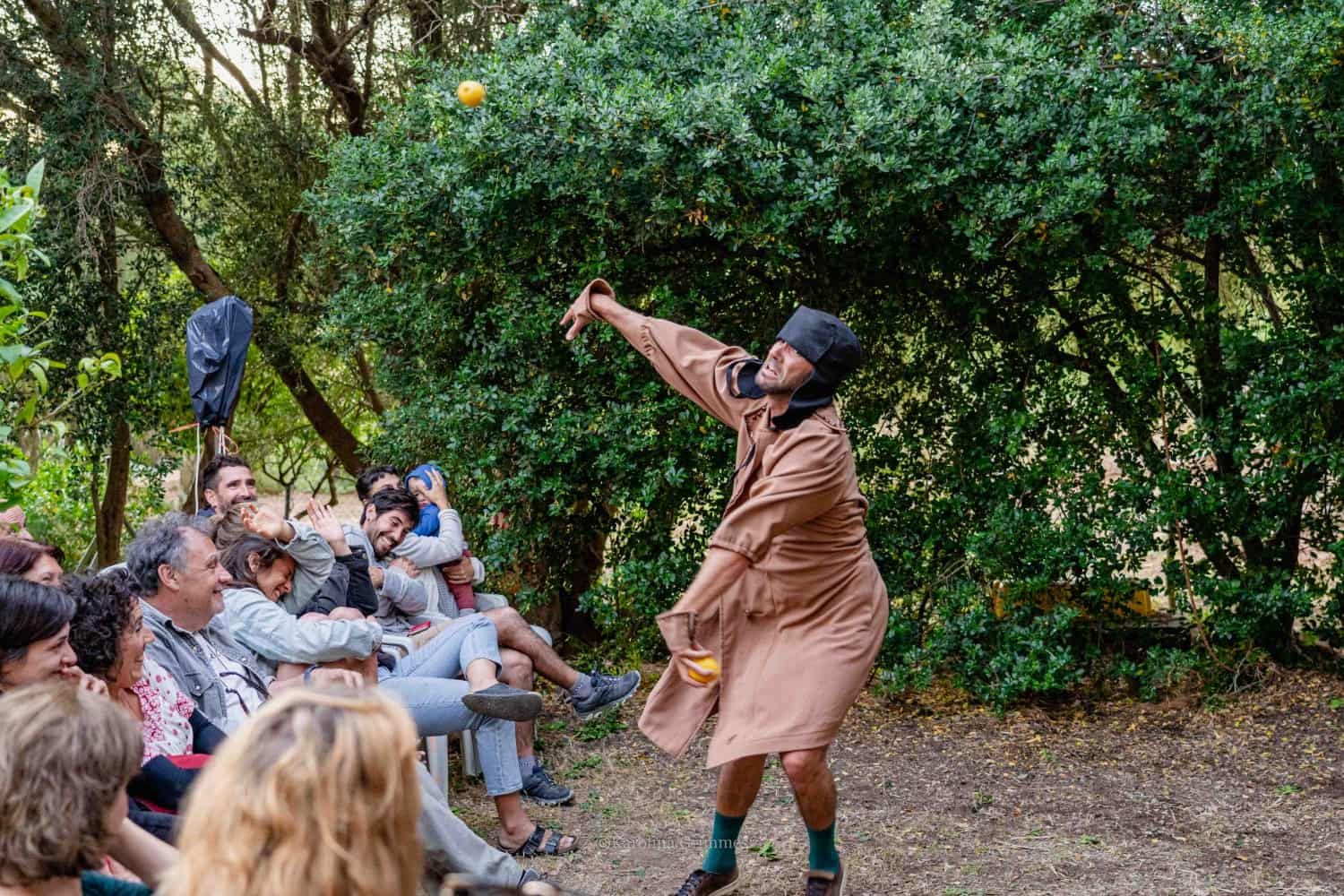 Un hombre está haciendo malabarismos con una pelota delante de una multitud de personas.