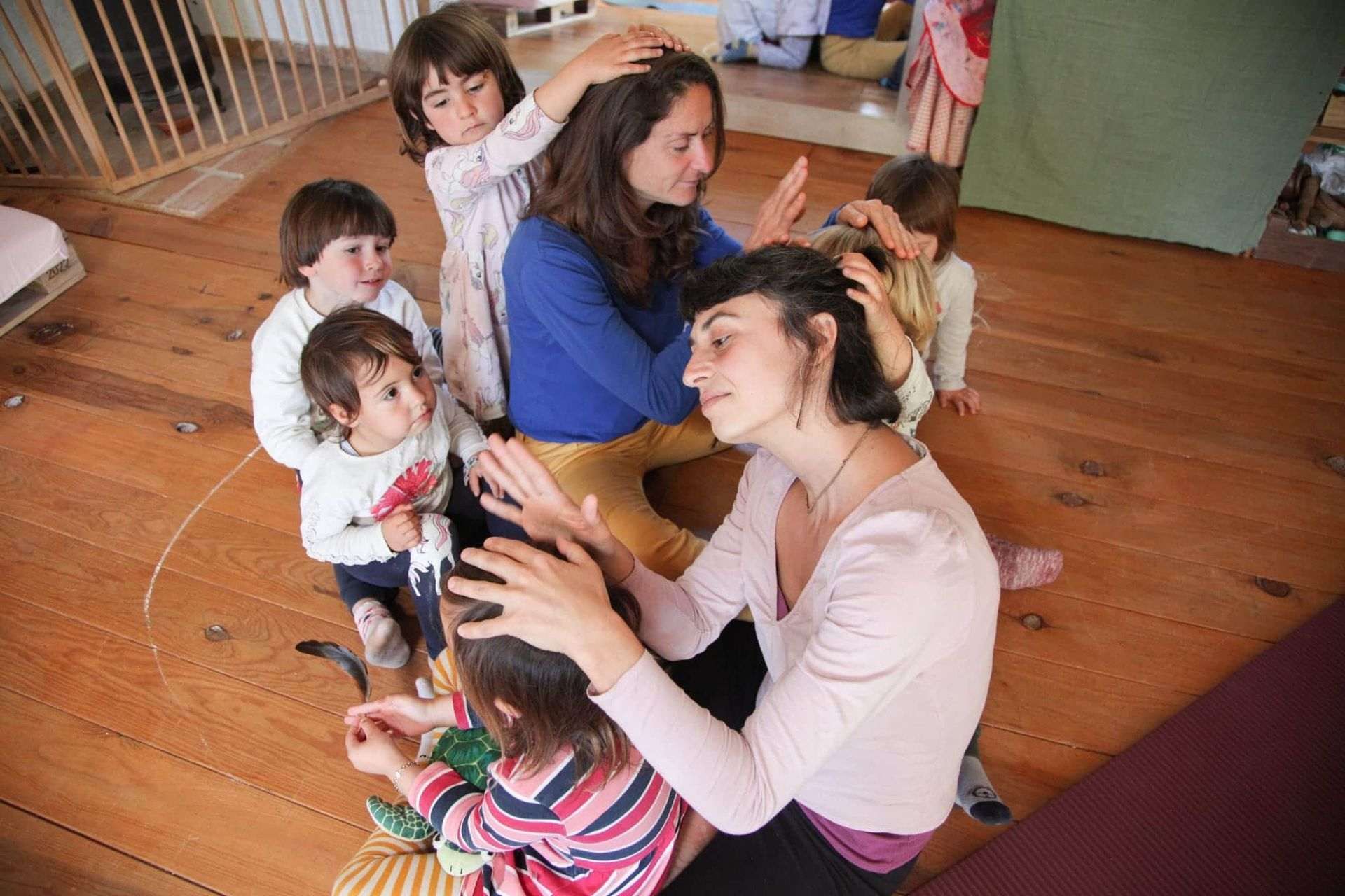 Una mujer está sentada en el suelo con un grupo de niños.