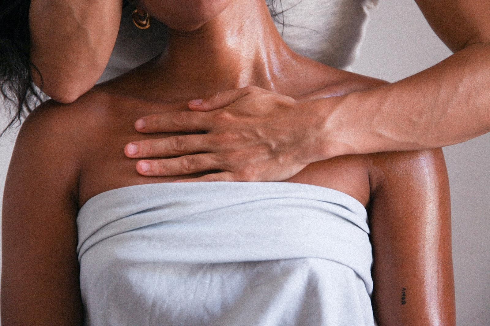 Una mujer envuelta en una toalla está recibiendo un masaje de un hombre.