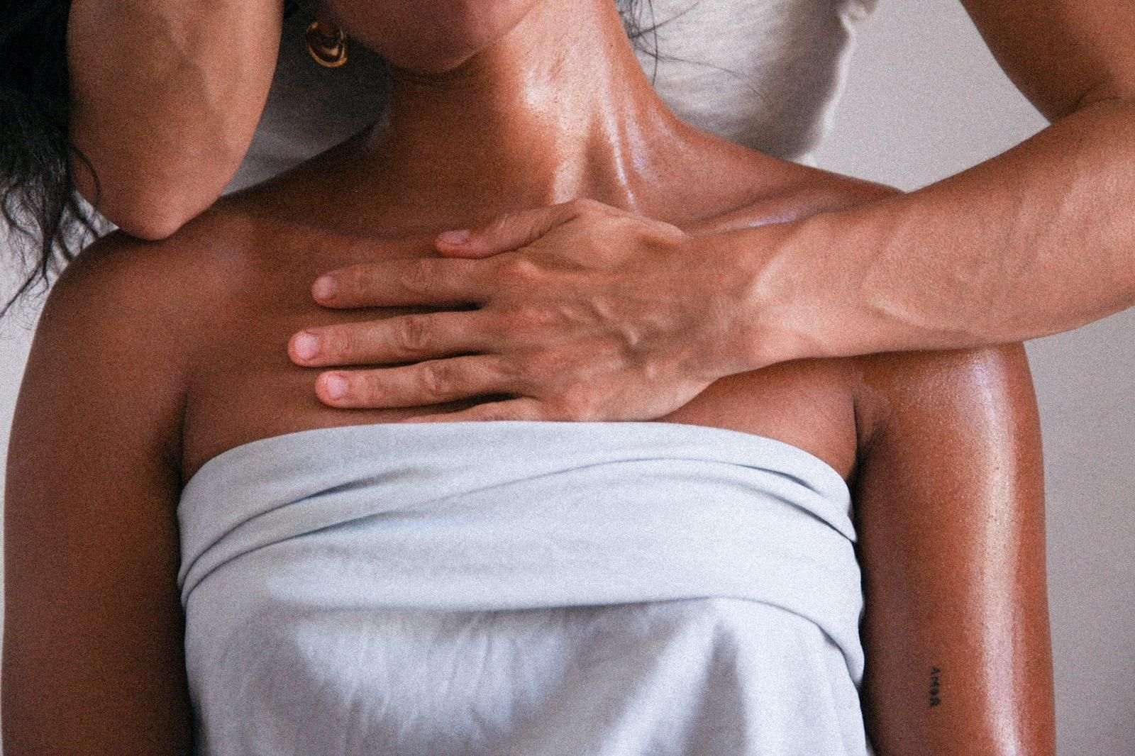 Una mujer envuelta en una toalla está recibiendo un masaje de un hombre.