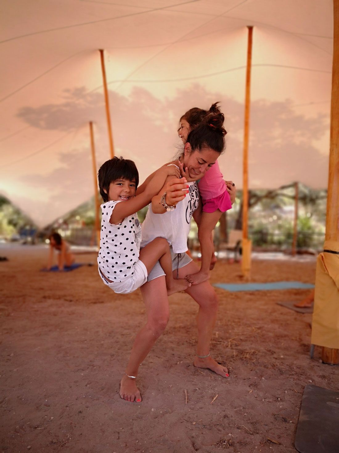 Una mujer lleva dos niños sobre sus hombros.