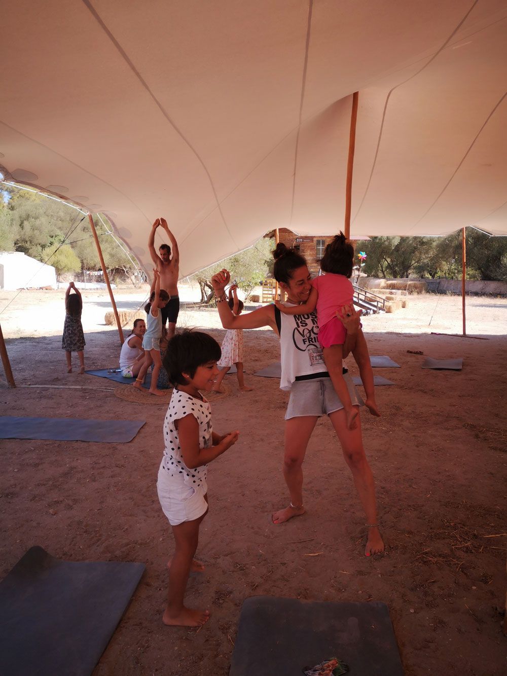 Una mujer lleva un niño sobre sus hombros en una tienda de campaña.