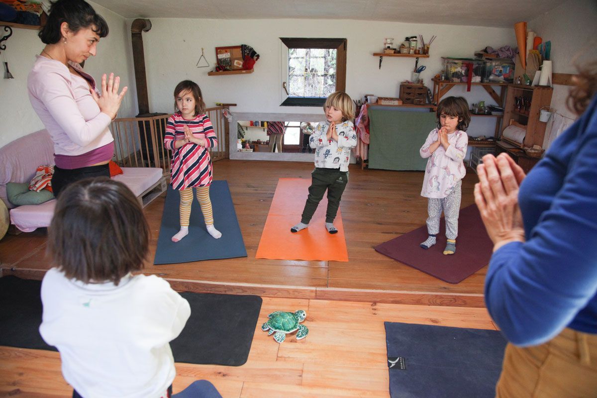 Un grupo de niños está practicando yoga en una habitación.