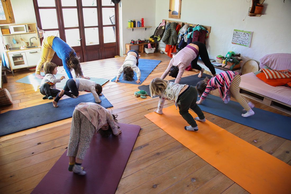 Un grupo de niños está haciendo yoga en una habitación.