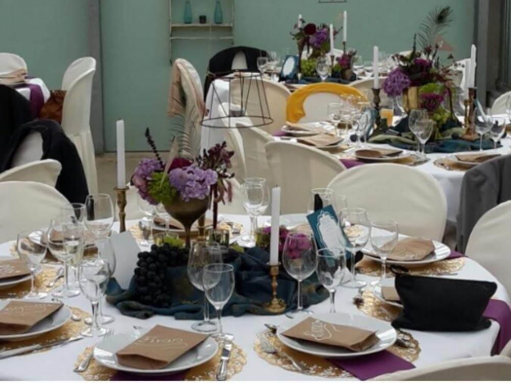 Ein für eine Party gedeckter Tisch mit Tellern, Kerzen und Blumen