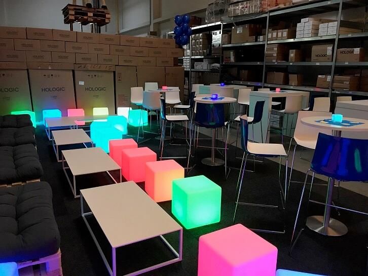 Ein Raum mit Tischen und Stühlen und leuchtenden Würfeln