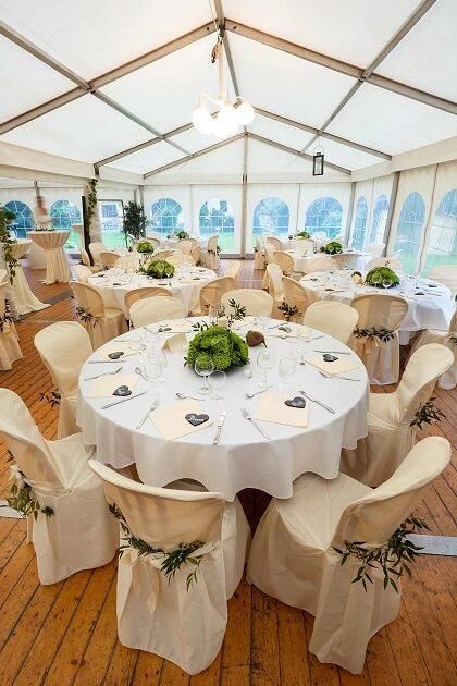Ein großes Zelt mit Tischen und Stühlen für einen Hochzeitsempfang