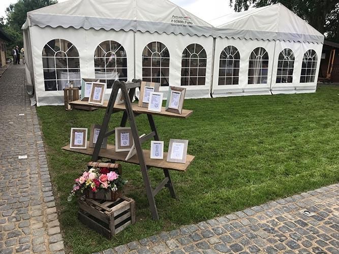 Auf einem üppigen grünen Feld steht ein weißes Zelt.