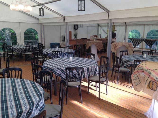 Ein großer Raum mit Tischen und Stühlen unter einem Zelt