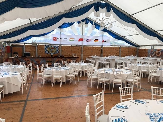 Ein großer Raum mit Tischen und Stühlen unter einem Zelt