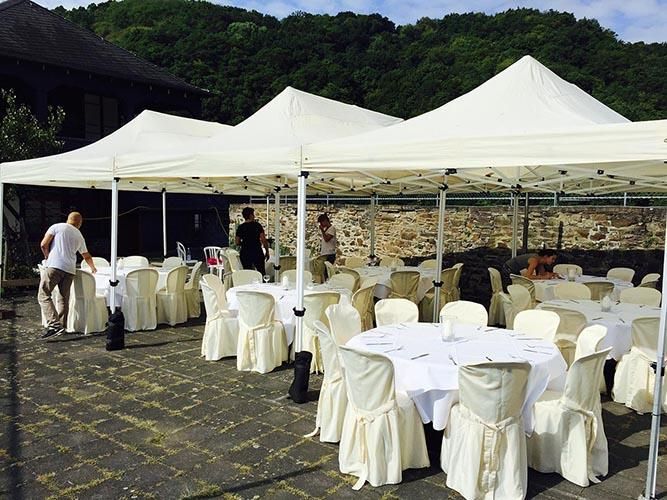 Eine Reihe weißer Zelte mit Tischen und Stühlen darunter
