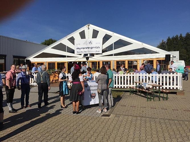 Eine Gruppe von Menschen steht vor einem großen Zelt.