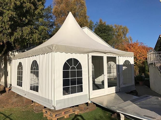 Auf einer Holzpalette steht ein großes weißes Zelt.