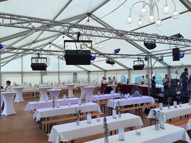 Ein großes Zelt mit Tischen und Bänken für eine Party
