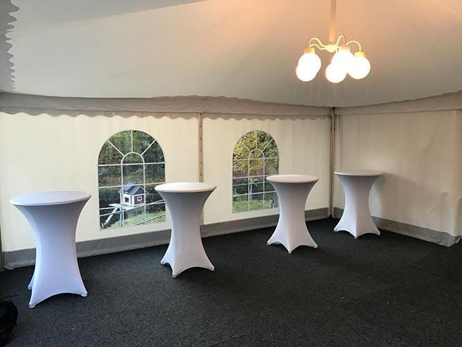 Ein Raum mit vier Tischen und einem Kronleuchter, der von der Decke hängt