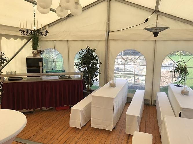 Ein Zelt mit Tischen und Bänken darin