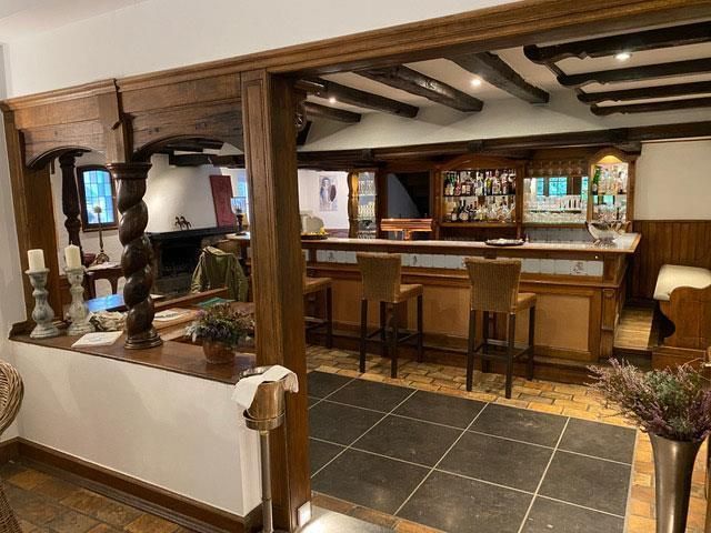 Ein großer Raum mit einer Bar und Stühlen darin.