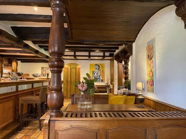 Auf dem Tisch in der Mitte des Zimmers steht eine Vase mit Blumen.