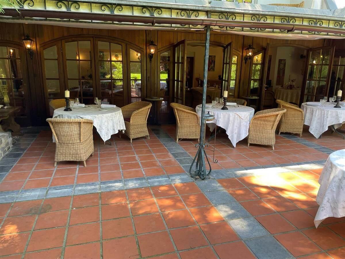 Ein Restaurant mit Tischen und Stühlen auf einer Terrasse.