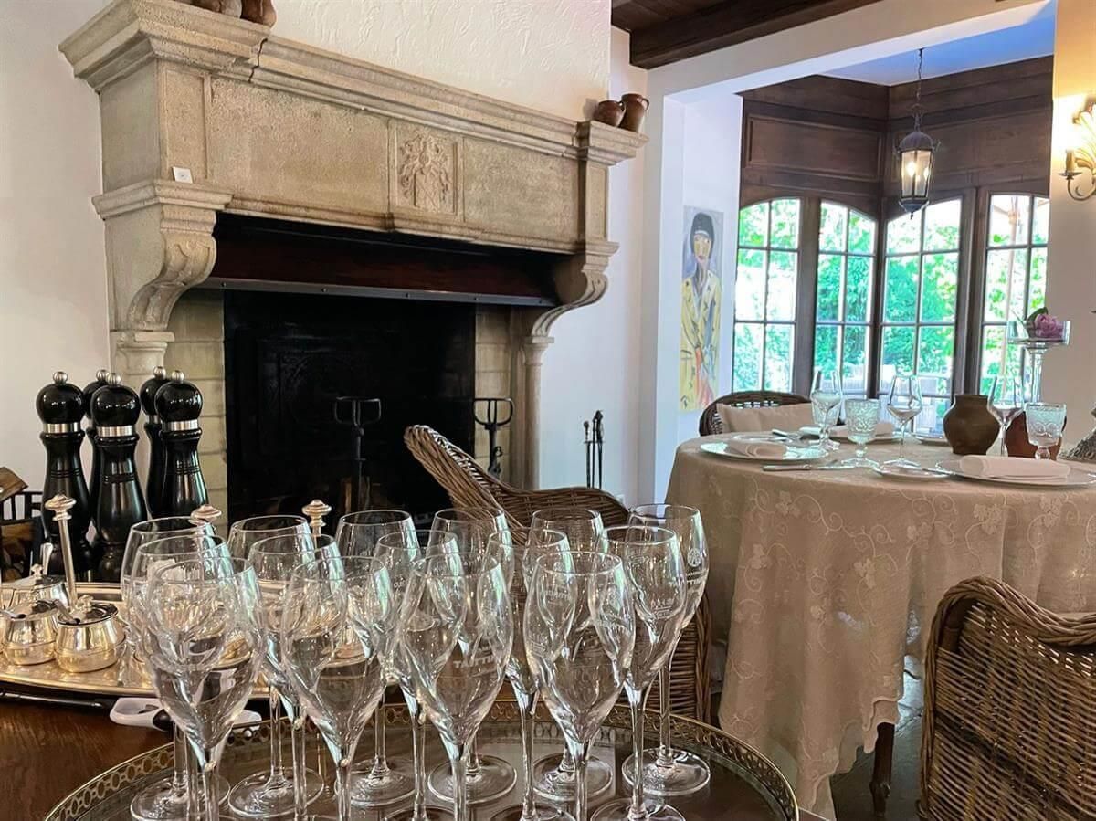 Ein Tablett mit Weingläsern steht auf einem Tisch vor einem Kamin.