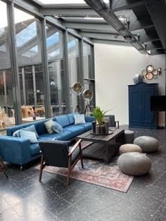 Ein Wohnzimmer voller Möbel und vielen Fenstern.